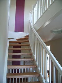 Treppe viertel gewendelt, Trittstufen aus Roteiche, Wangen und Geländer weiß lackiert
